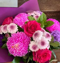 Bouquet of pink, purple, and white flowers with green leaves 
